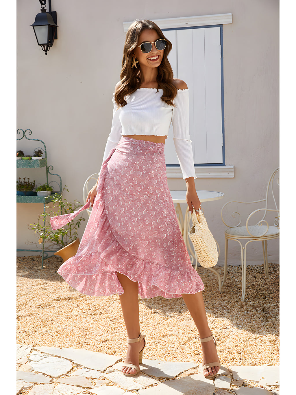 Jupe midi hippie portefeuille rose fleurie portée avec un crop-top blanc