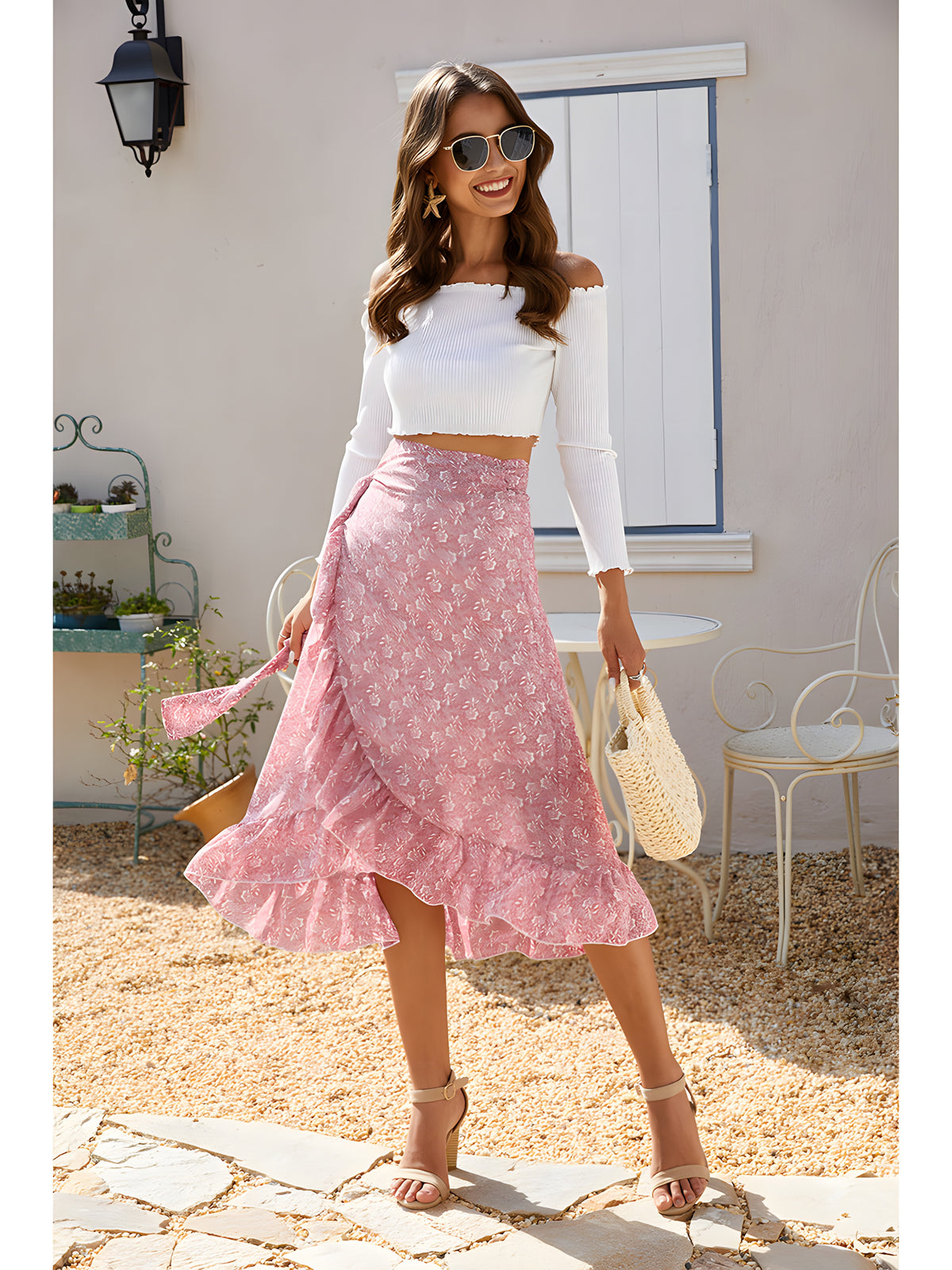 Jupe midi hippie portefeuille rose fleurie portée avec un crop-top blanc