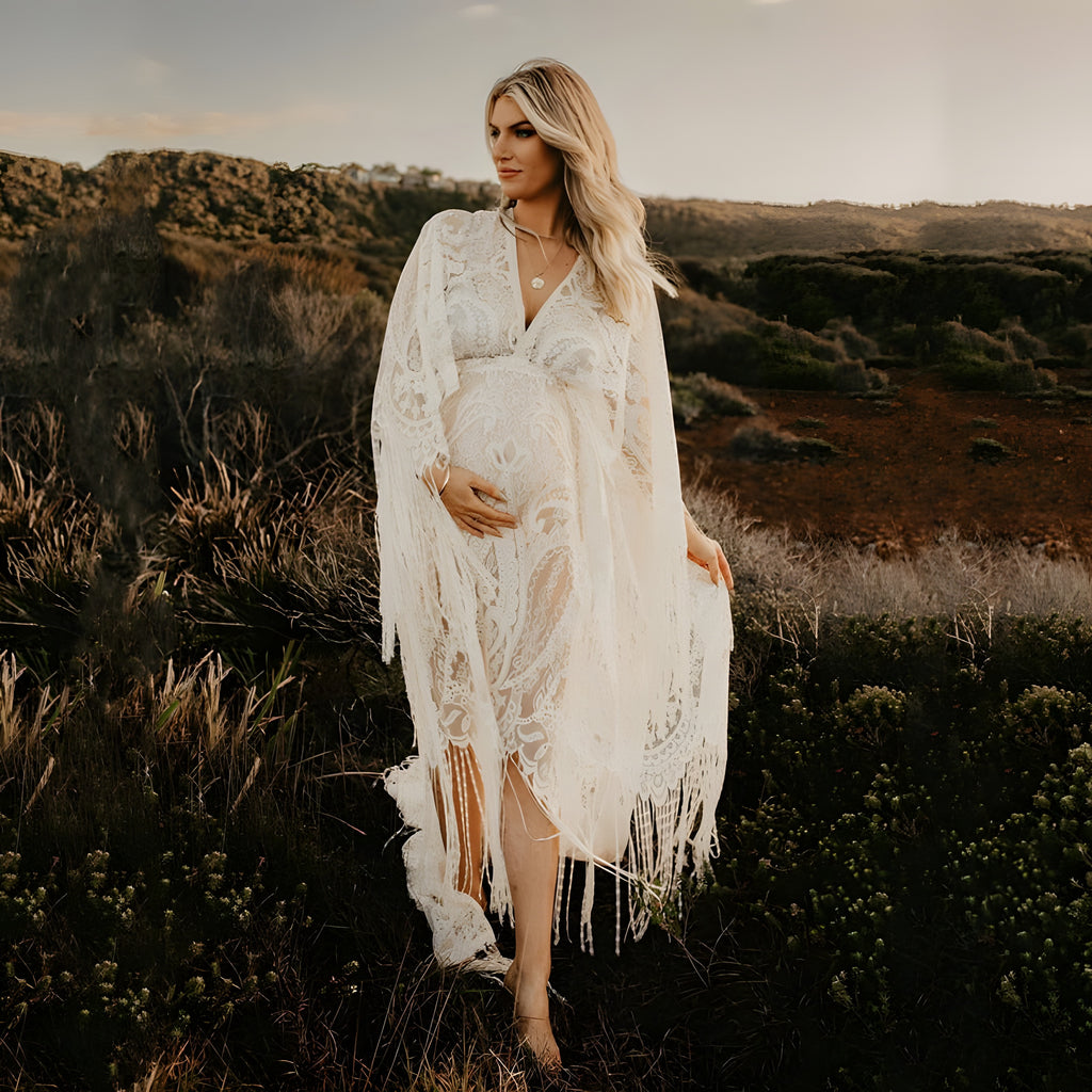 Robe de grossesse bohème en dentelle ivoire portée par un modèle souriant au coucher de soleil