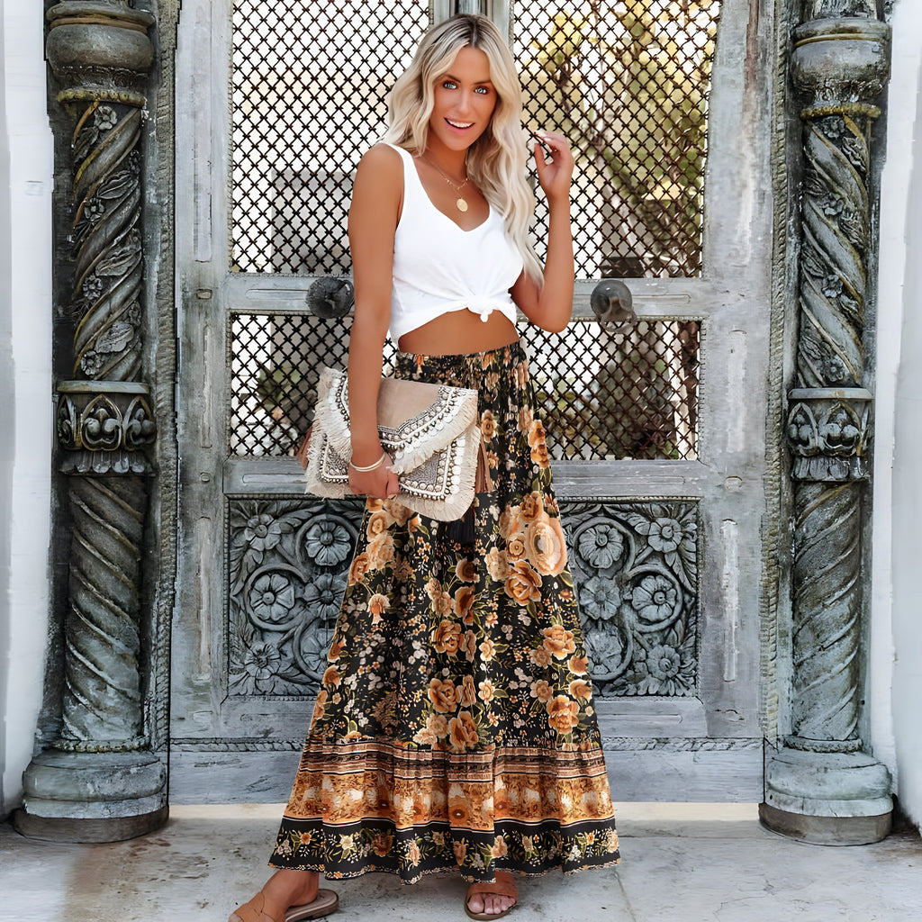 Jupe longue hippie noire fleurie portée avec un crop-top blanc noué
