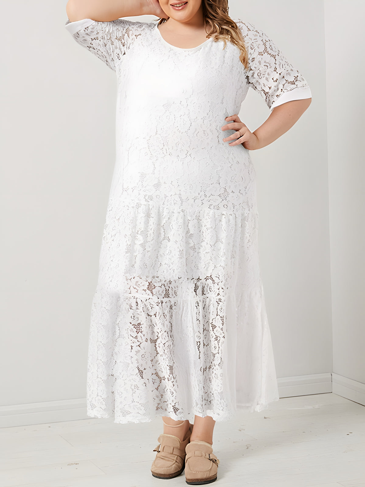 Modèle souriante grande taille portant la robe longue en dentelle bohème blanche