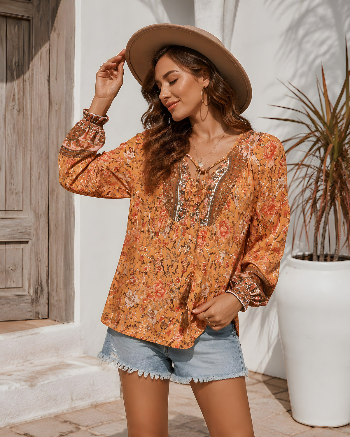 Chemise blouse hippie orange à imprimé fleuri portée avec un short en jean