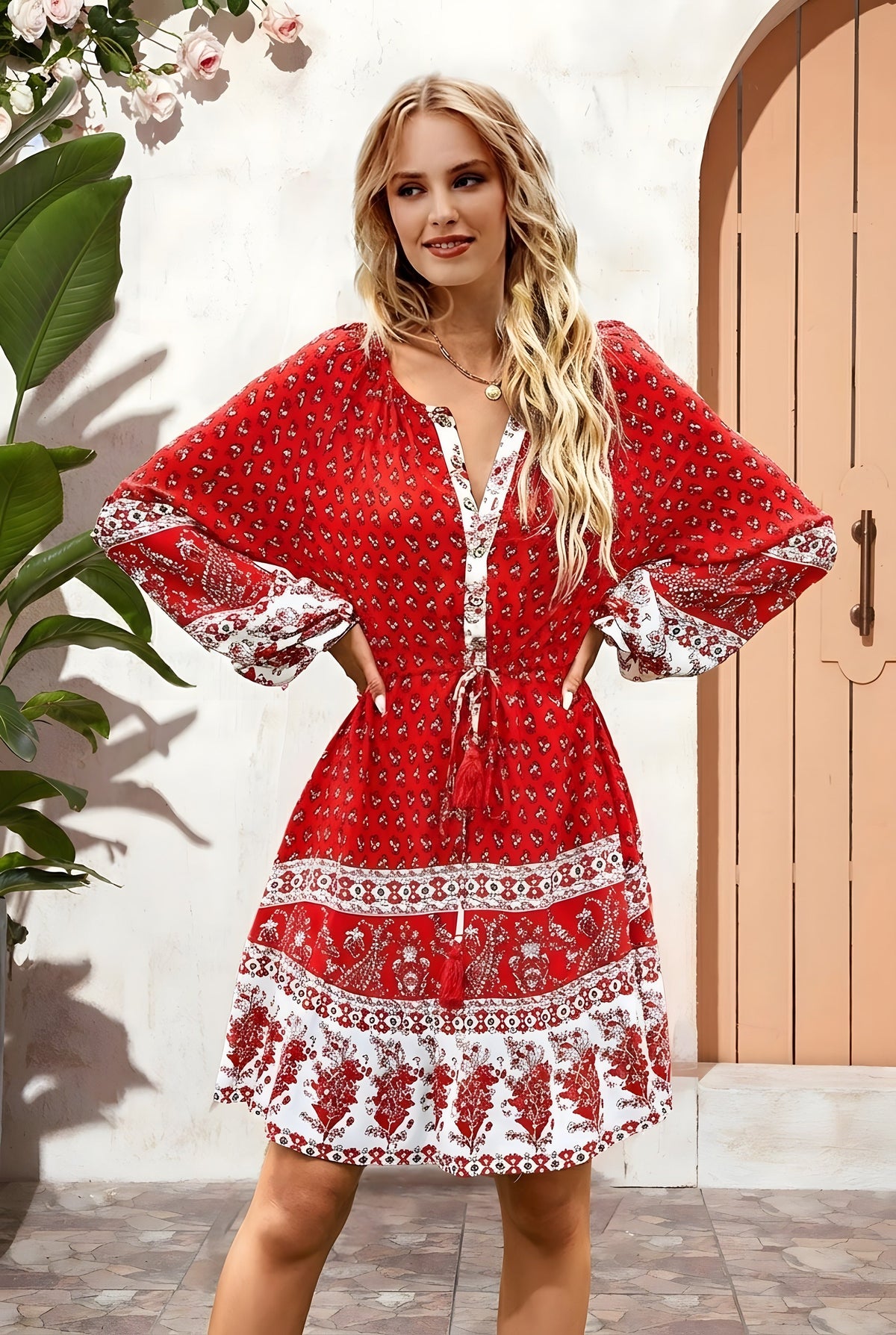 Robe courte hippie chic rouge portée devant une porte cintrée