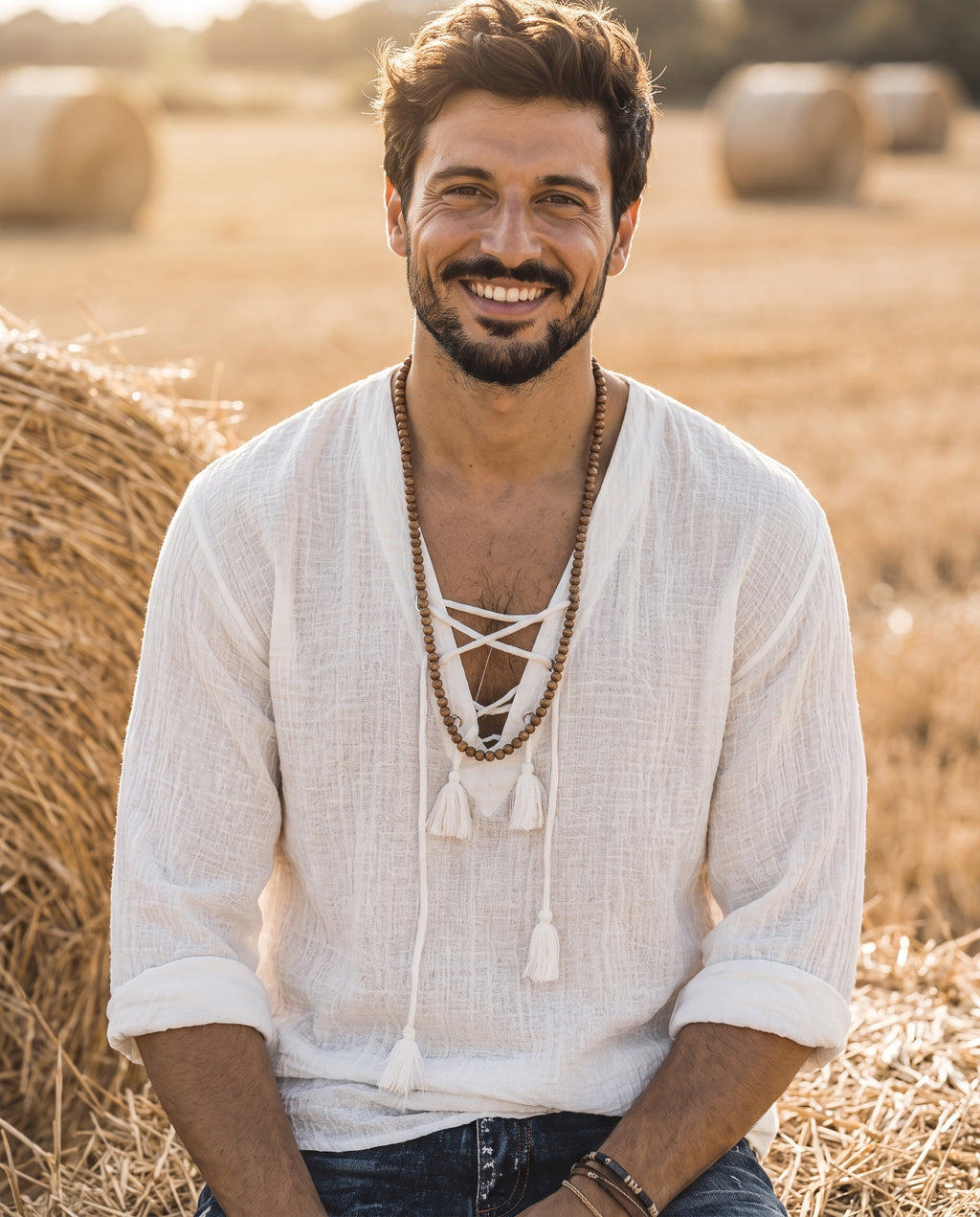 T-shirt hippie homme blanc porté par un modèle souriant dans un champ au soleil