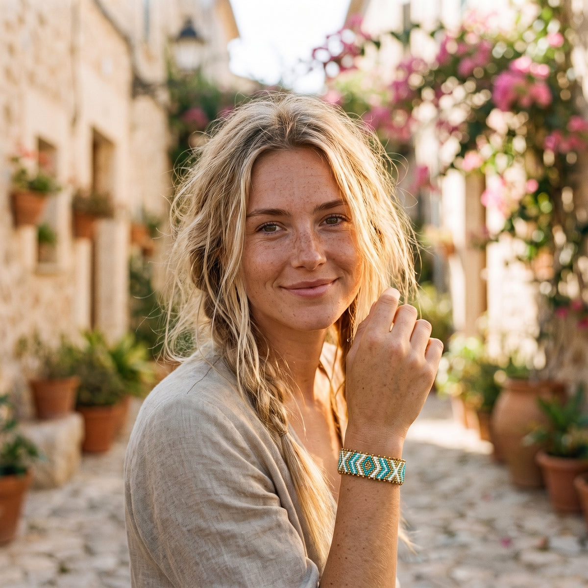 Bracelet brésilien tissé turquoise porté au poignet par un modèle souriant
