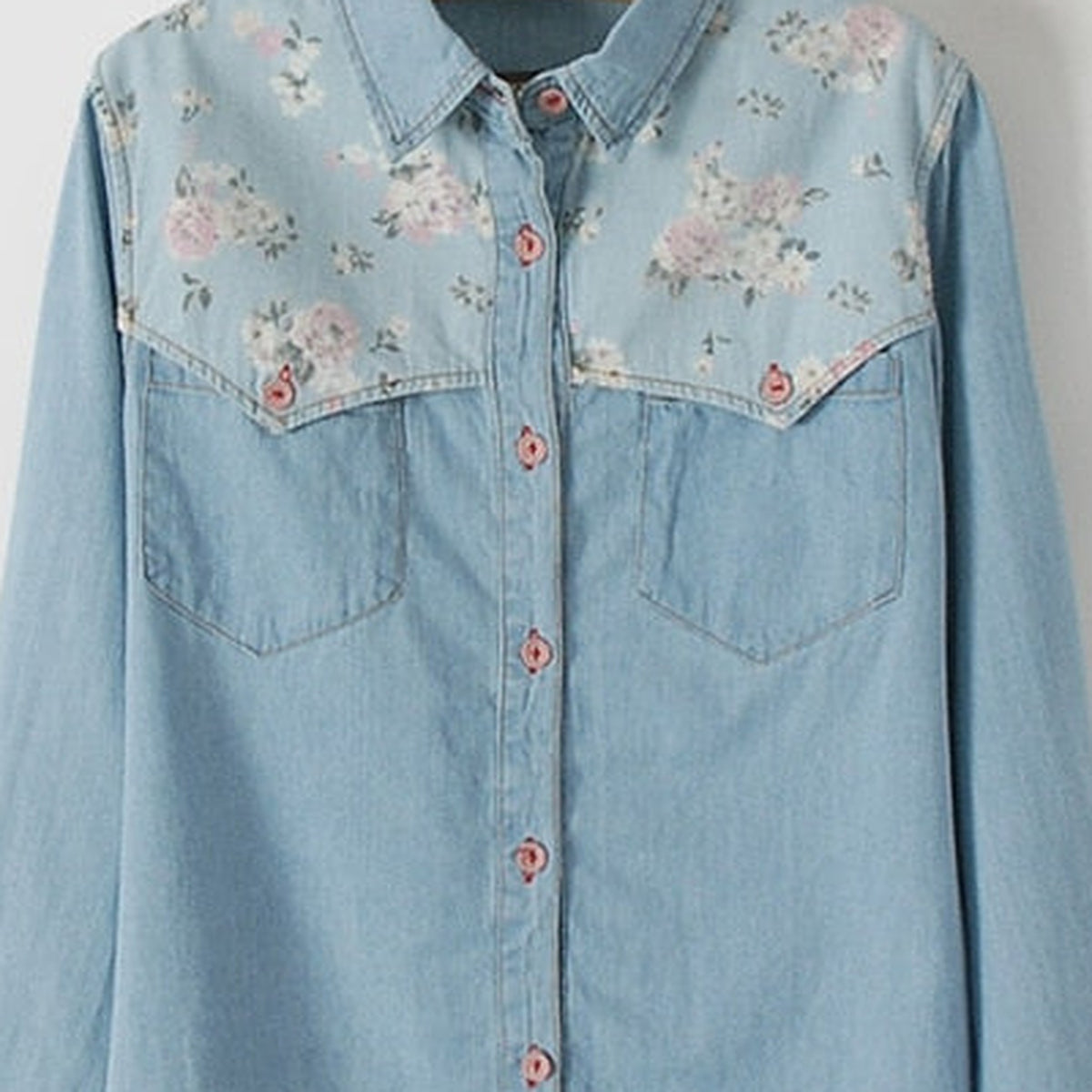 Gros plan de l'empiècement floral roses sur le jean délavé