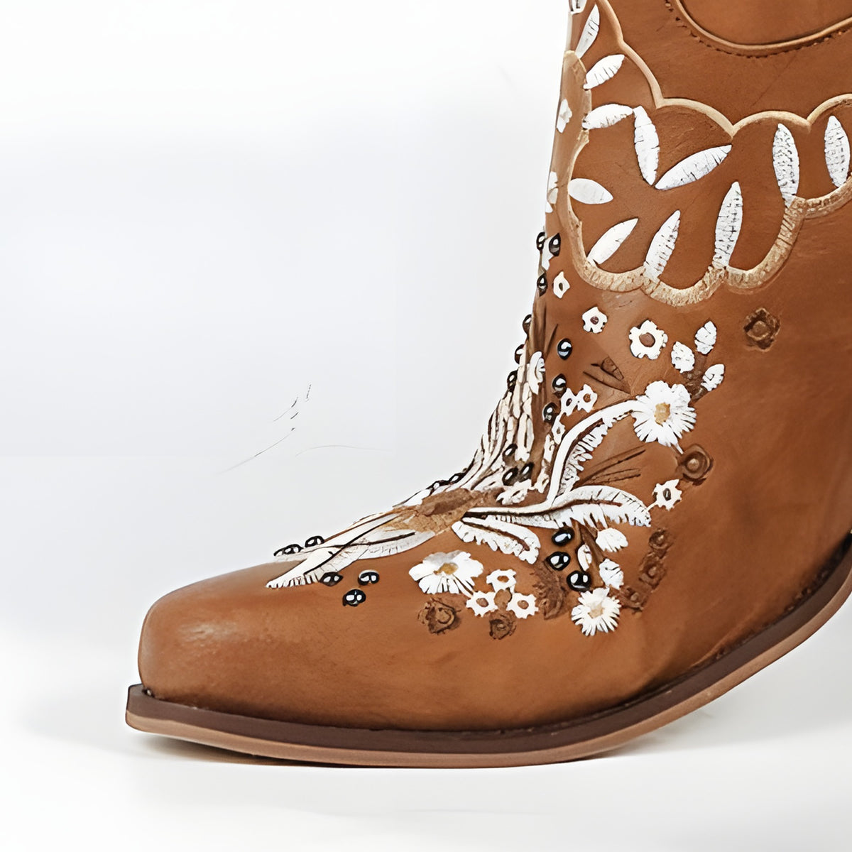Détail du bout effilé et de la broderie fleurie de la botte camel