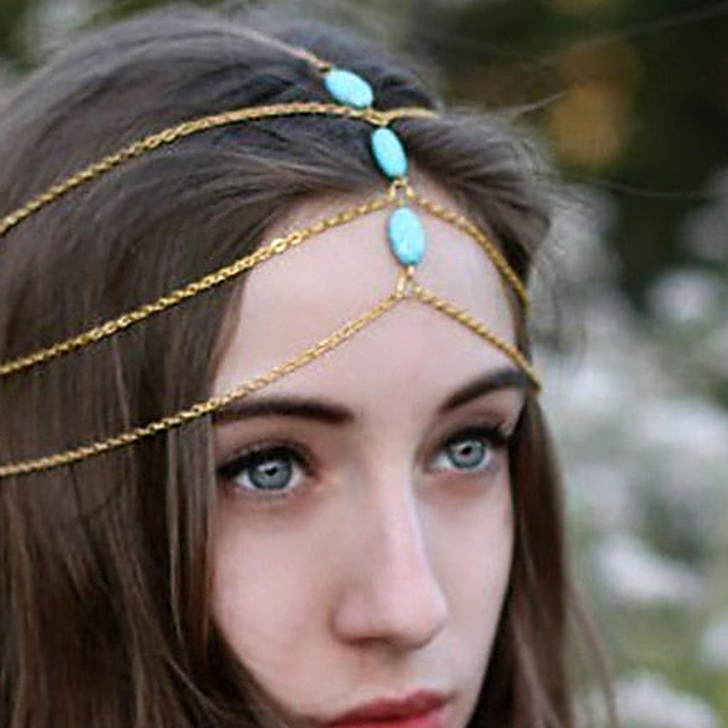 Détail des trois pierres turquoise et des chaînes dorées du bijou de tête