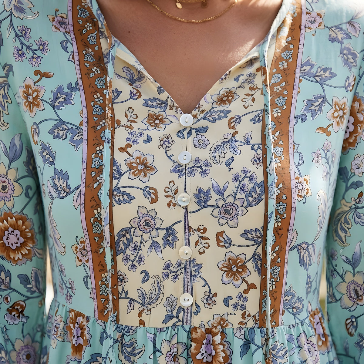 Détail du col V boutonné et de l'empiècement crème de la robe hippie fleurie Bild