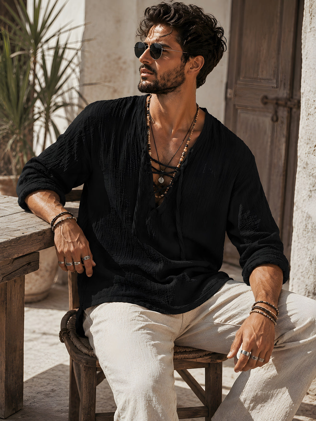 T-shirt hippie homme noir porté assis sur une terrasse