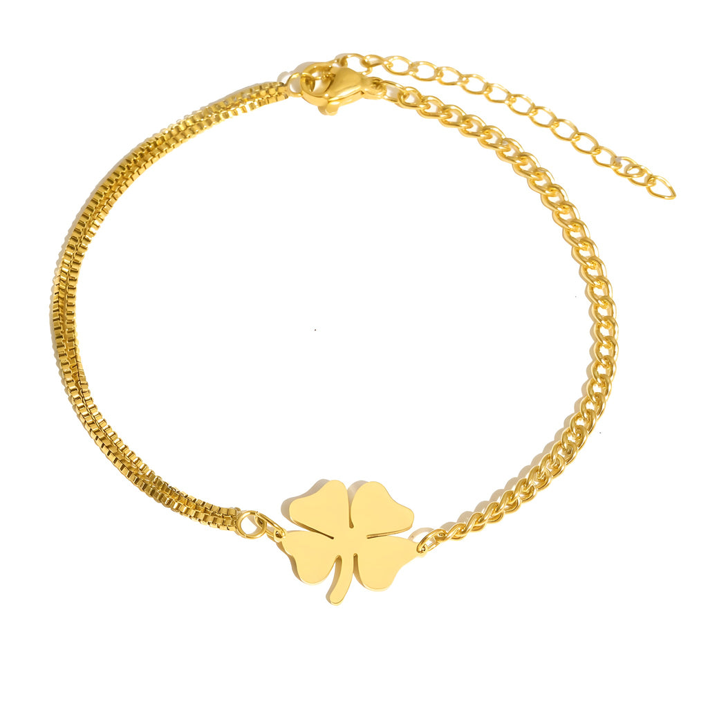 Bracelet trèfle 4 feuilles doré à plat sur fond blanc, chaîne asymétrique