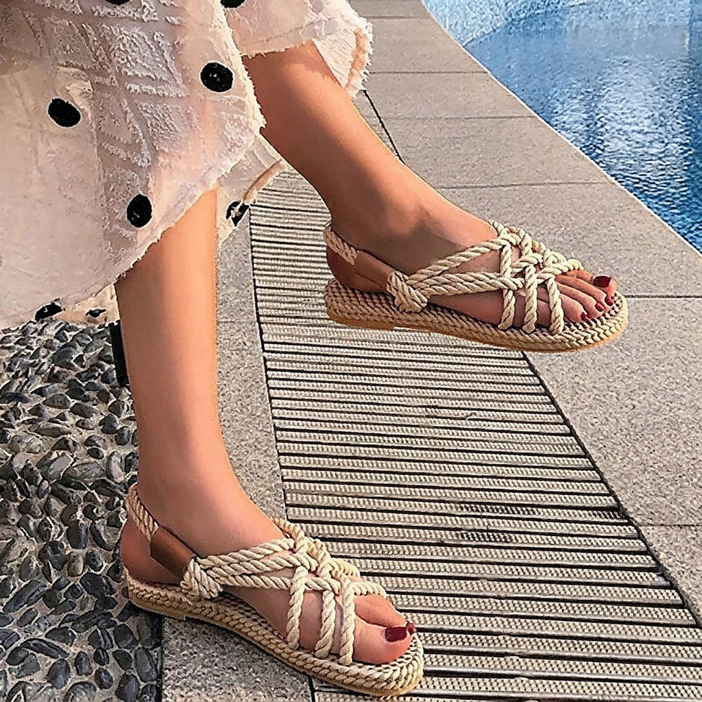 Sandales plates hippie en corde tressée beige portées au bord de l'eau