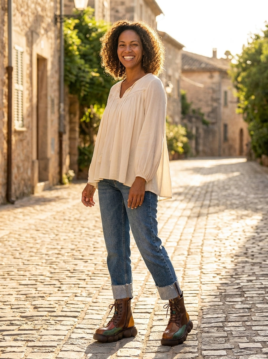 Modèle souriante en bottines bohème multicolores, rue de village Image