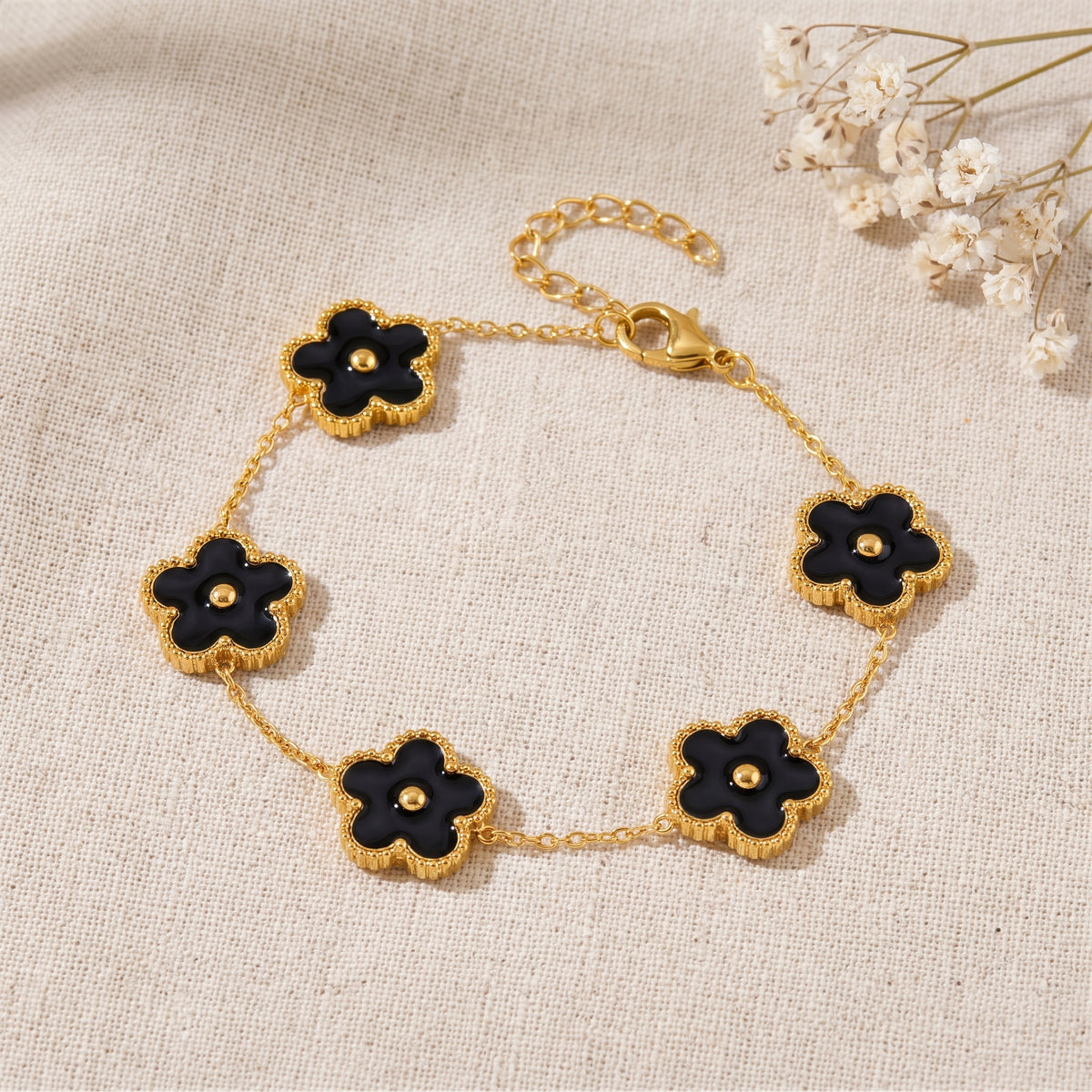 Bracelet fleur 5 pétales noir façon Alhambra, bouton doré central, chaîne dorée