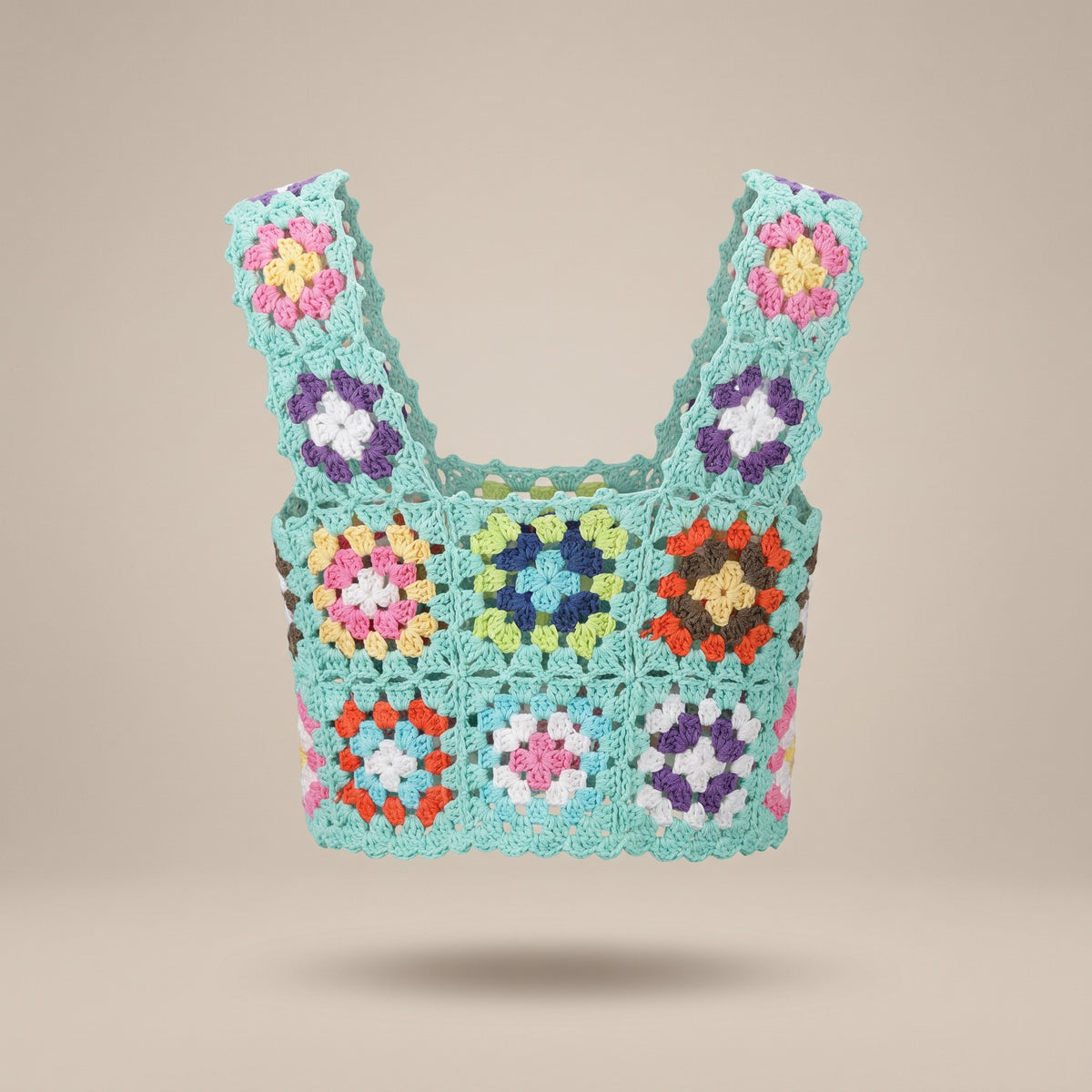 Crop-top au crochet vert d'eau à fleurs multicolores, vue produit sur fond écru