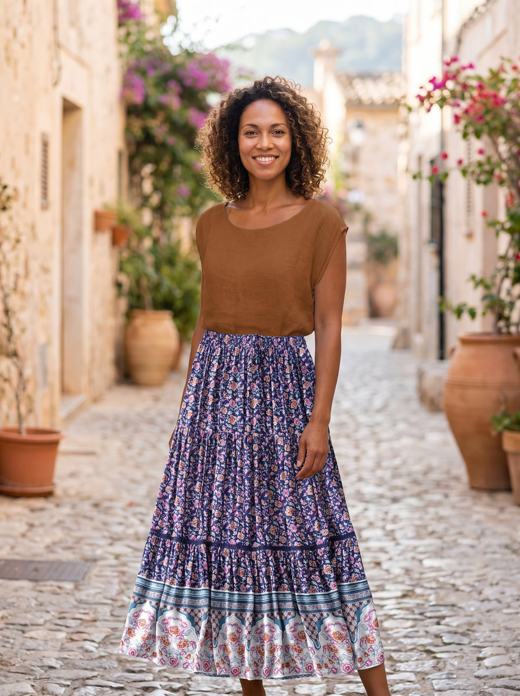 Modèle souriante, jupe longue hippie bohème fleurie, ruelle méditerranéenne pavée