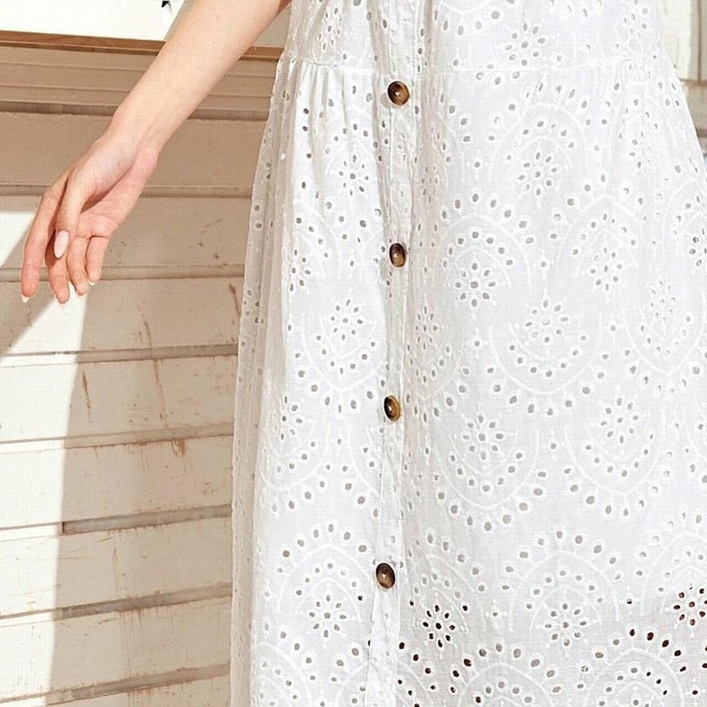 Gros plan broderie anglaise ajourée et boutons en bois