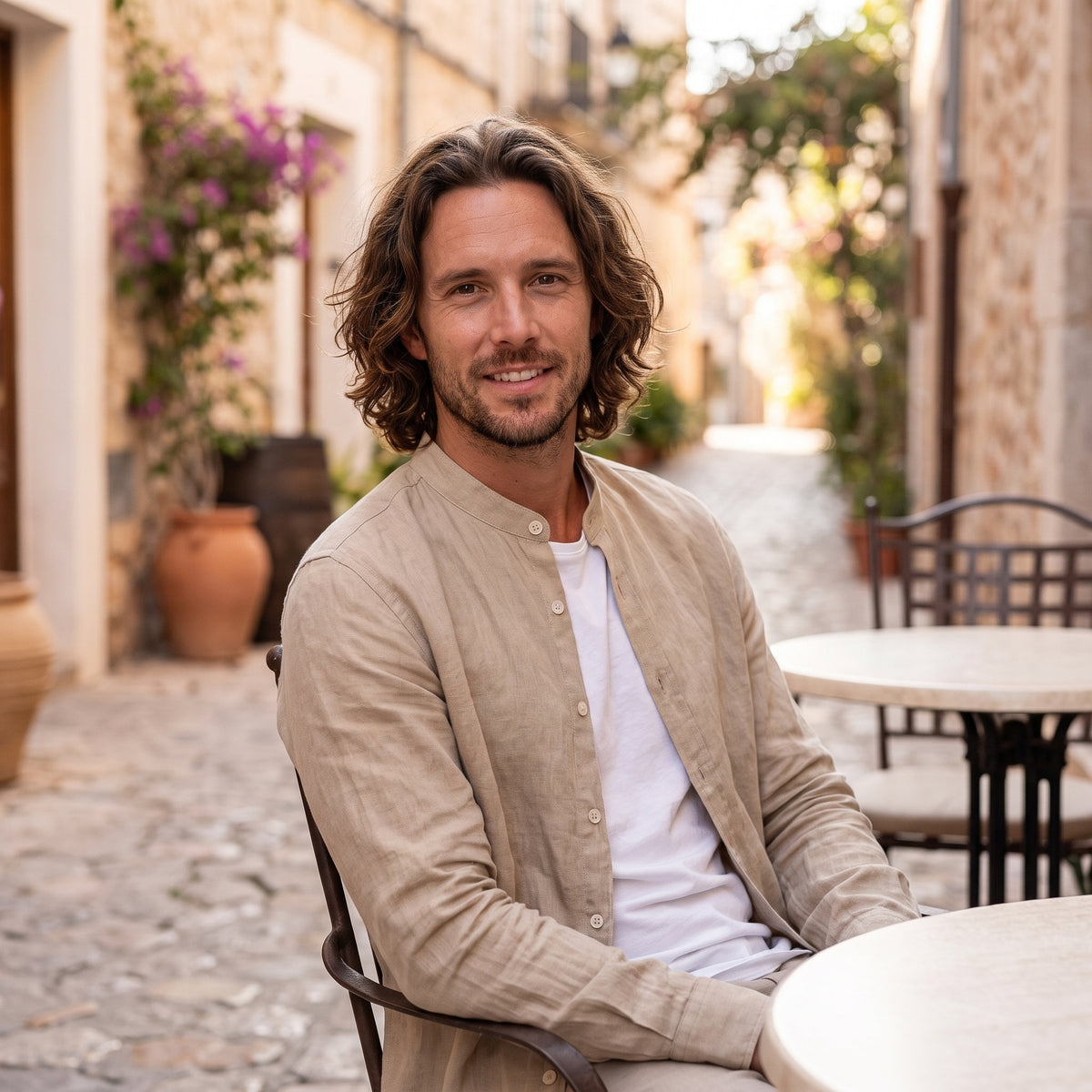 Modèle assis à une terrasse portant la chemise hippie homme effet lin beige