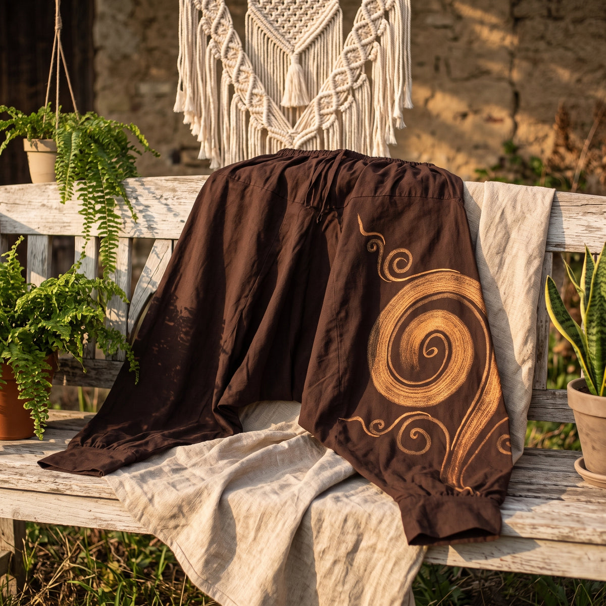 Sarouel homme marron spirale dorée drapé sur banc bois, décor bohème macramé