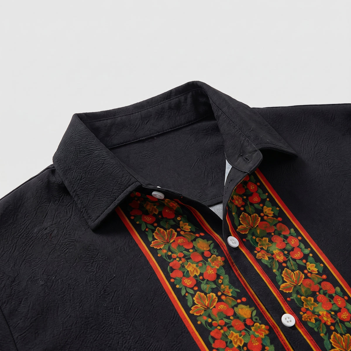 Détail du col cubain et de la bordure fleurie de la chemise hippie homme Bild