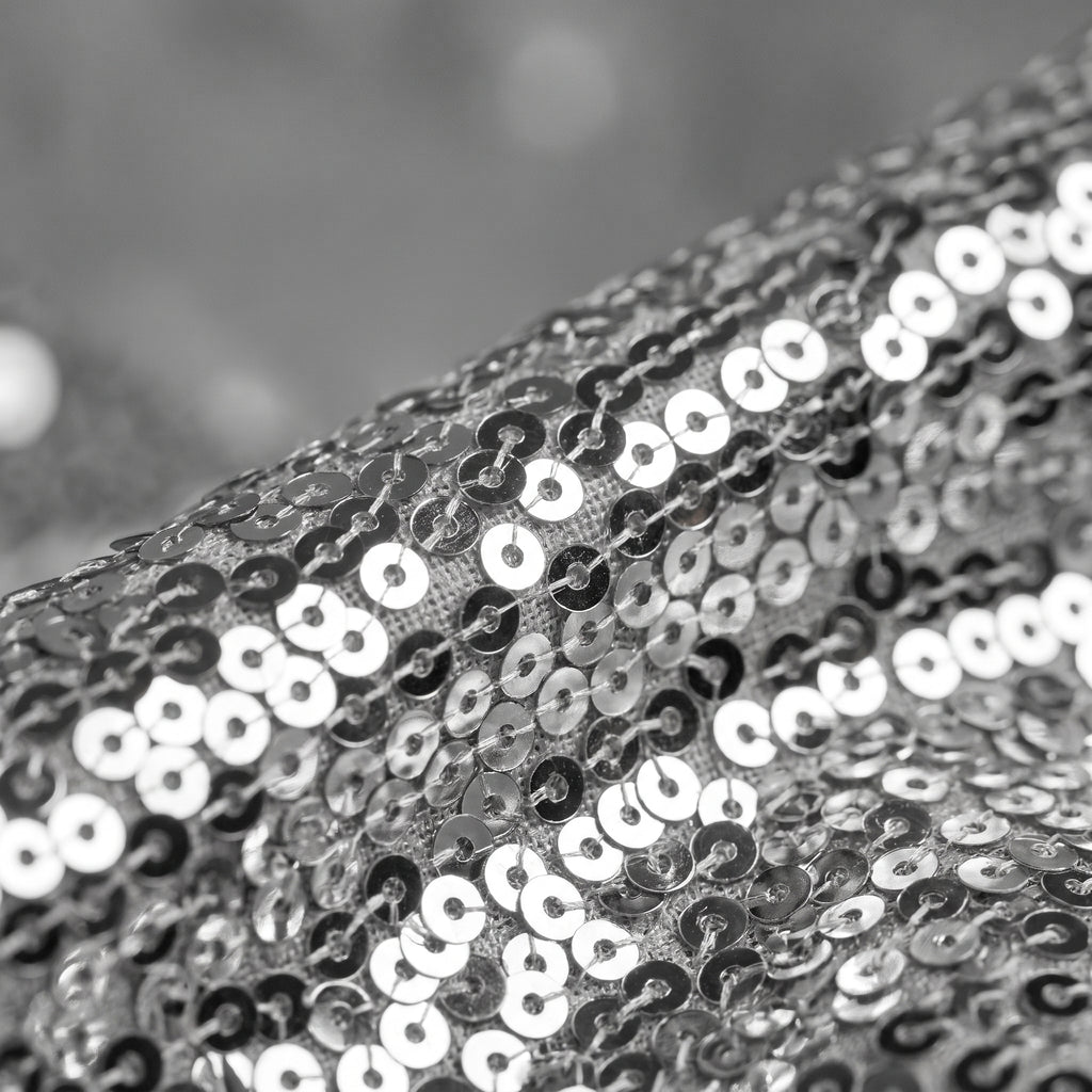 Gros plan sur les sequins argentés du pantalon patte d'éléphant