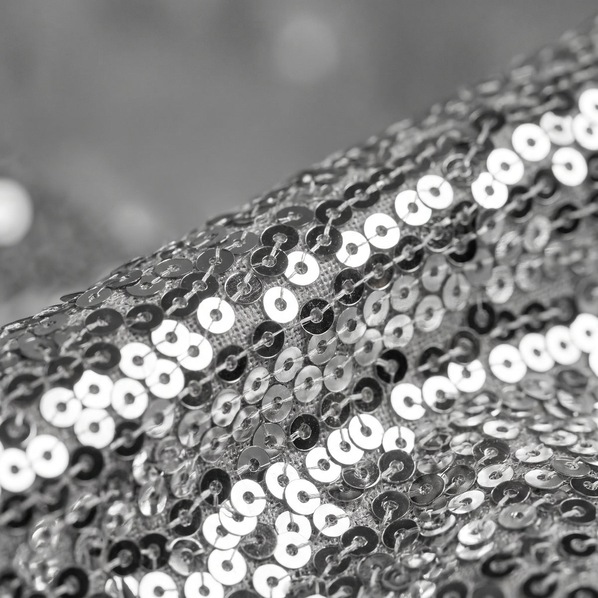 Gros plan sur les sequins argentés du pantalon patte d'éléphant