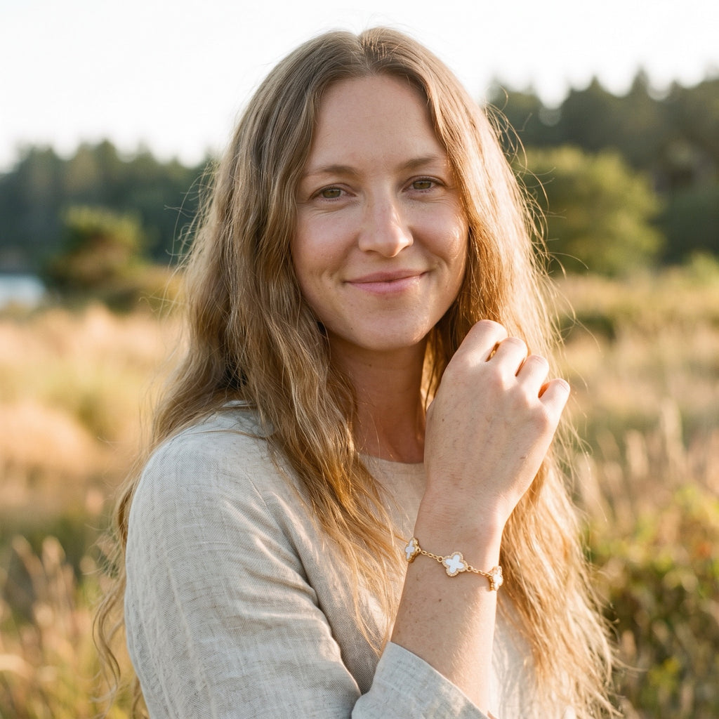Bracelet trèfle porte-bonheur blanc porté au poignet, femme souriante