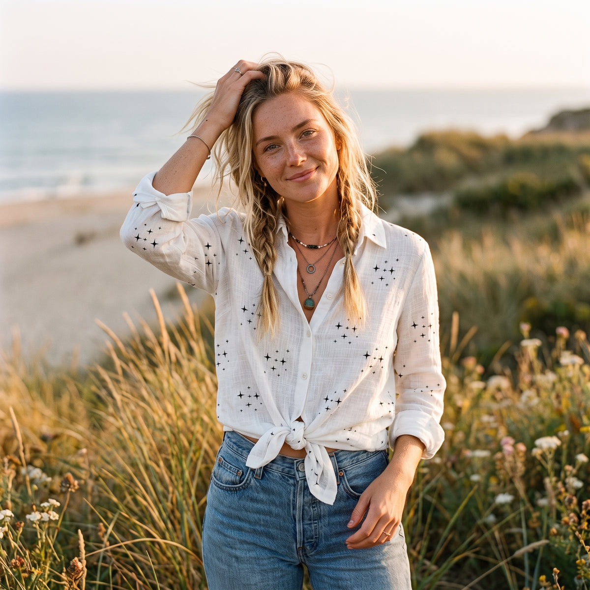 Chemise blanche hippie femme étoiles nouée à la taille manches retroussées bord de mer