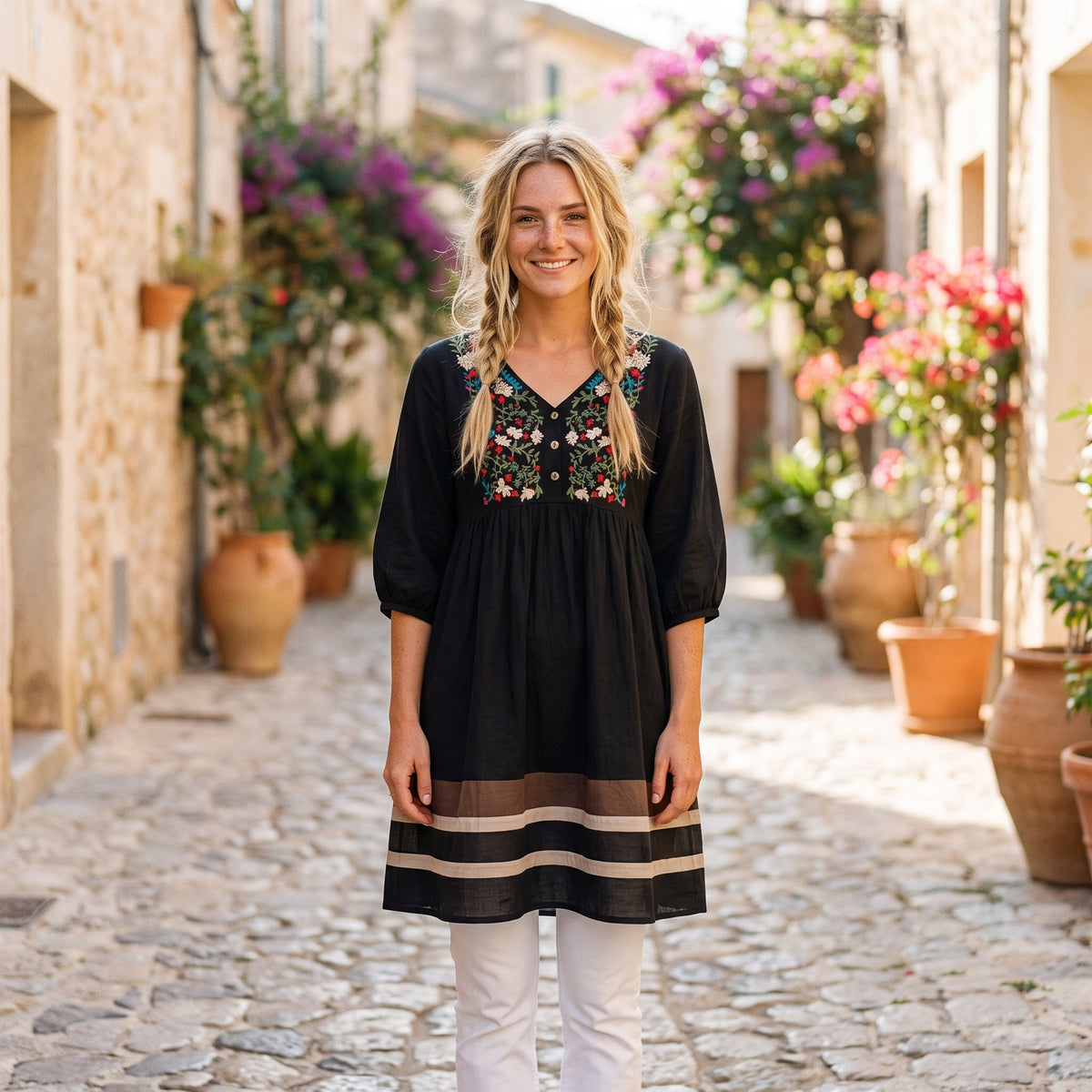 Robe-tunique mexicaine brodée noire portée par un modèle souriant