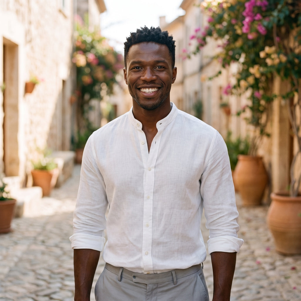 Chemise homme en lin blanc portée par un modèle souriant en ruelle méditerranéenne