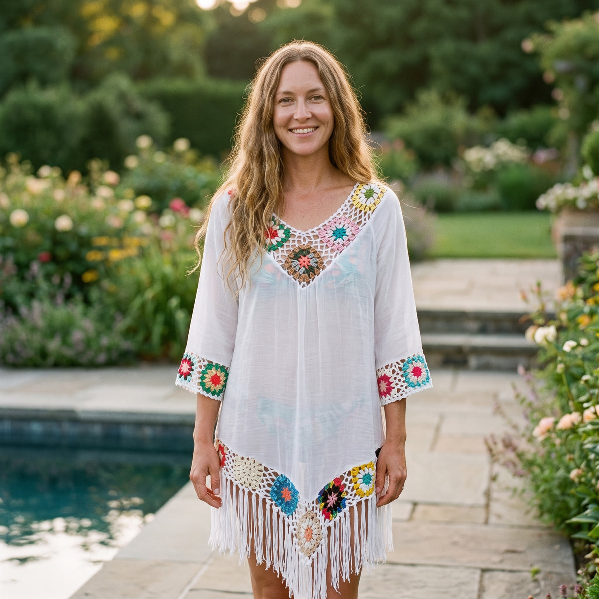 Tunique de plage crochet multicolore blanche portée par un modèle souriant au bord d'une piscine