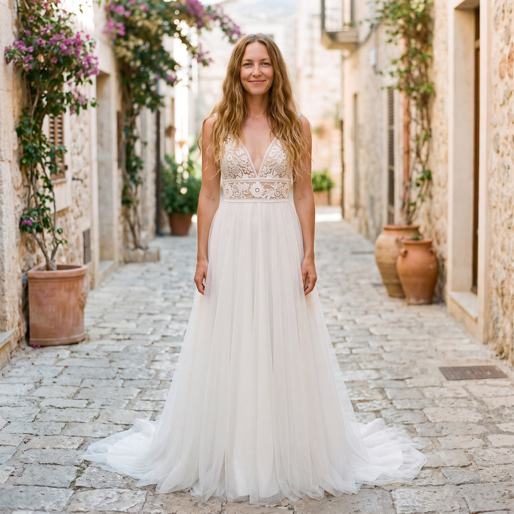 Robe de mariée bohème en tulle portée par un modèle souriant, ruelle méditerranéenne