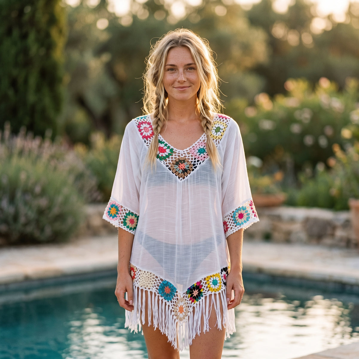 Tunique de plage crochet multicolore portée par un modèle souriant au bord d'une piscine