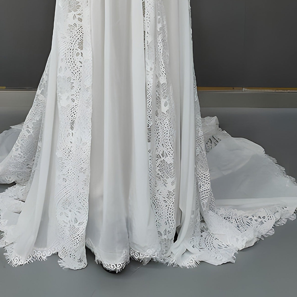 Détail des panneaux ajourés, de l’ourlet et de la traîne de la robe de mariée bohème