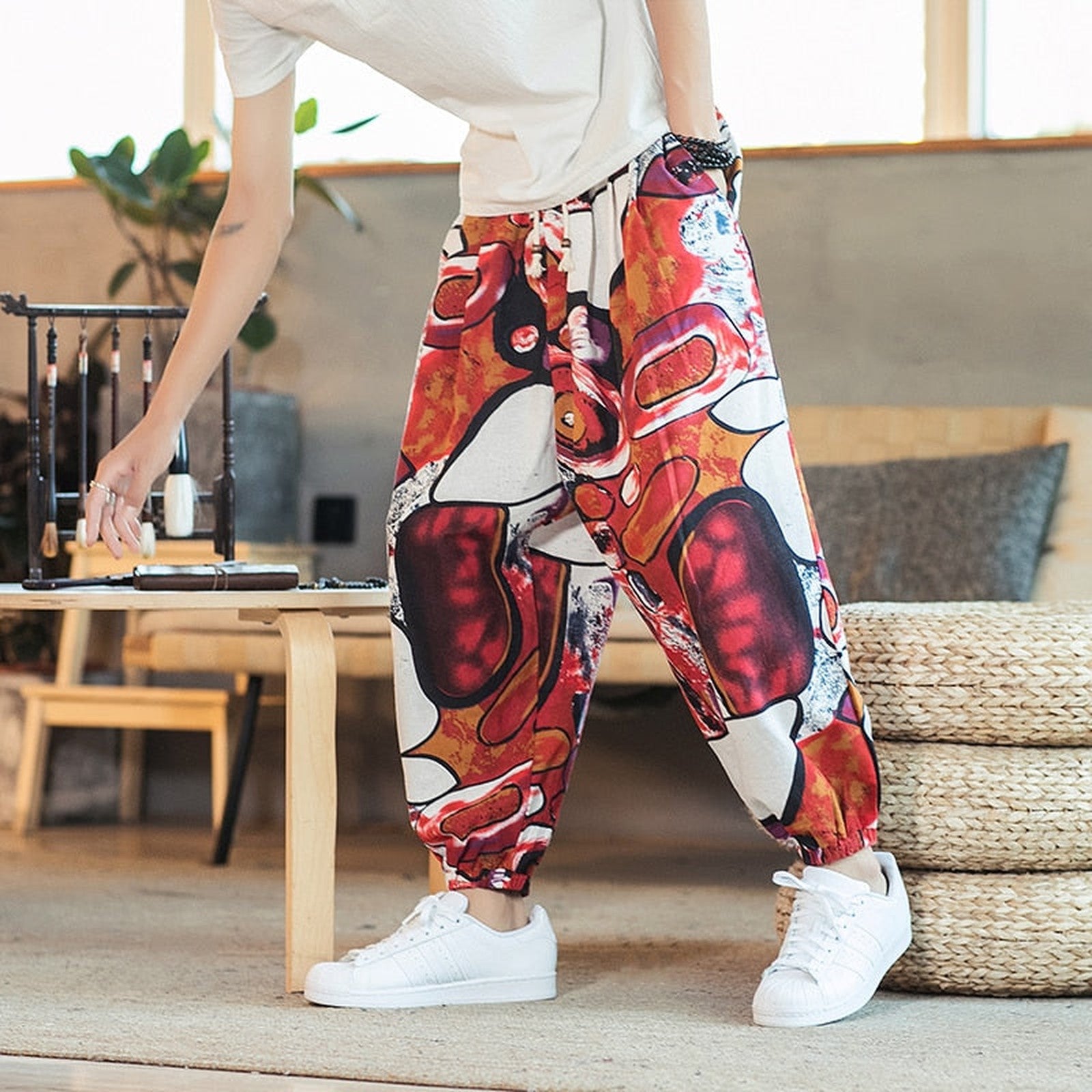 Pantalon hippie chic homme coloris rouge motif abstrait porté Bild