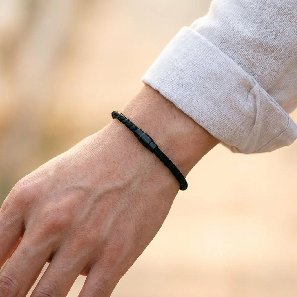 Bracelet corde tressée noire porté au poignet
